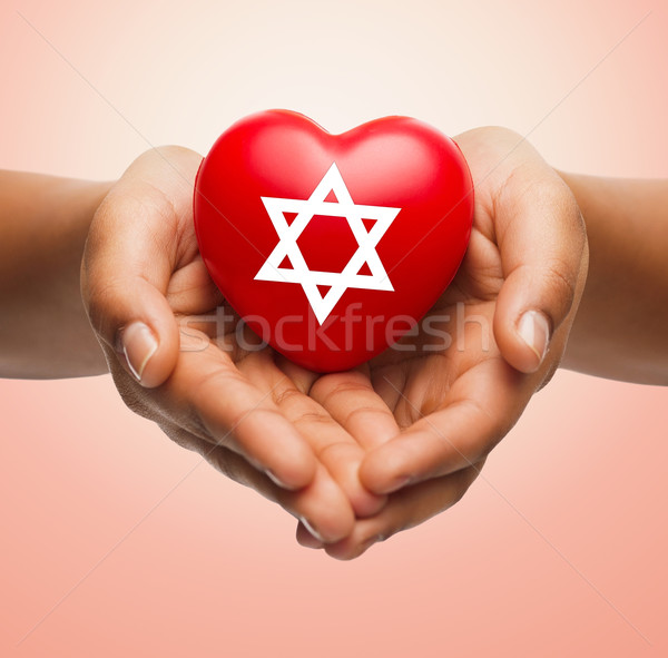 Stock photo: close up of hands holding heart with jewish star