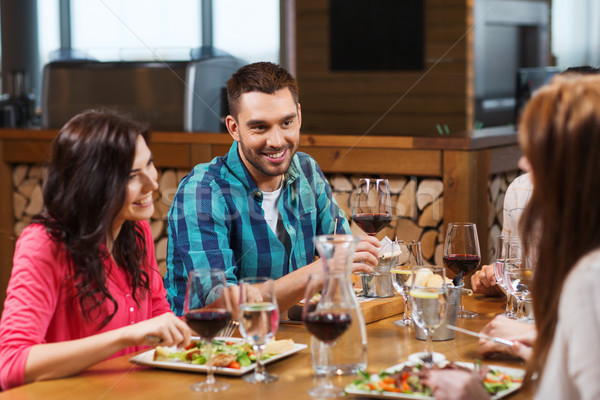 friends dining and drinking wine at restaurant Stock photo © dolgachov