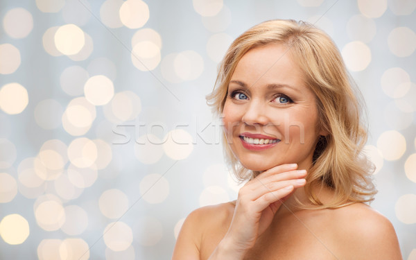 smiling woman with bare shoulders touching face Stock photo © dolgachov