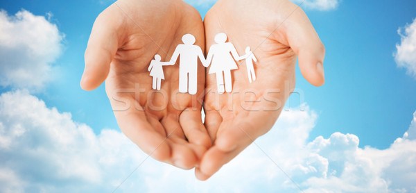 man hands holding paper cutout of family Stock photo © dolgachov