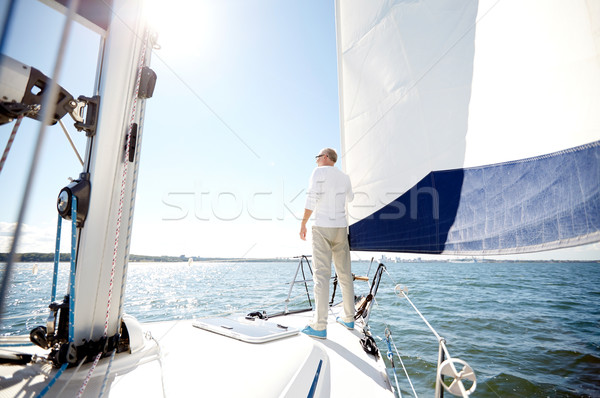 senior man on sail boat or yacht sailing in sea Stock photo © dolgachov