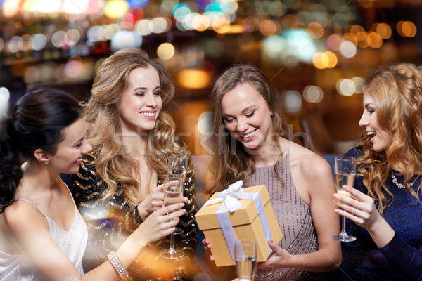 happy women with champagne and gift at night club Stock photo © dolgachov