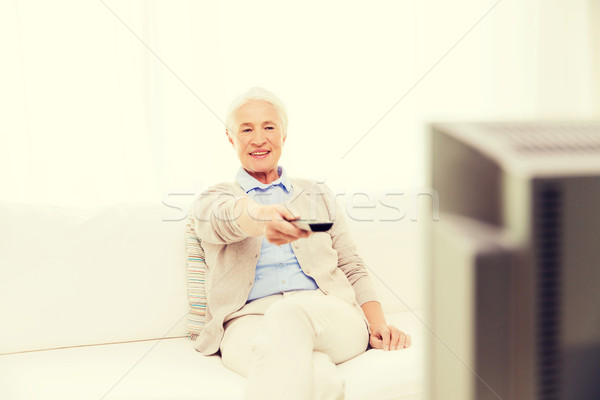Stock photo: happy senior woman watching tv at home