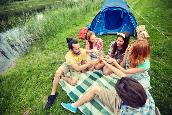 Stock photo: happy friends with tent and drinks at campsite