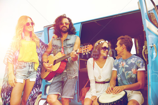 happy hippie friends playing music over minivan Stock photo © dolgachov