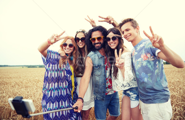 hippie friends with smartphone on selfie stick Stock photo © dolgachov