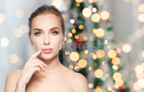 beautiful woman showing lips over christmas lights Stock photo © dolgachov