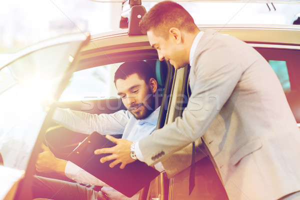 Stock photo: happy man with car dealer in auto show or salon