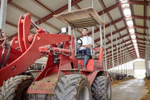 man or farmer driving tractor at farm Stock photo © dolgachov