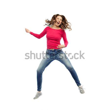 happy woman jumping and pretending guitar playing Stock photo © dolgachov
