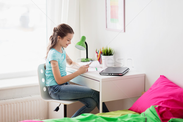 girl with laptop and smartphone texting at home Stock photo © dolgachov
