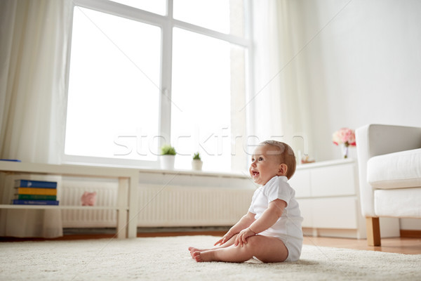 happy baby boy or girl sitting on floor at home Stock photo © dolgachov