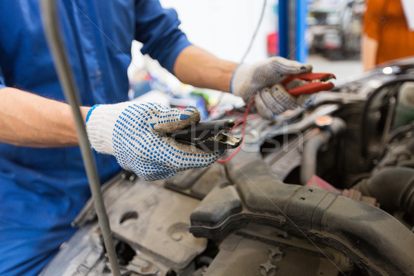 auto mechanic man with cleats charging battery Stock photo © dolgachov