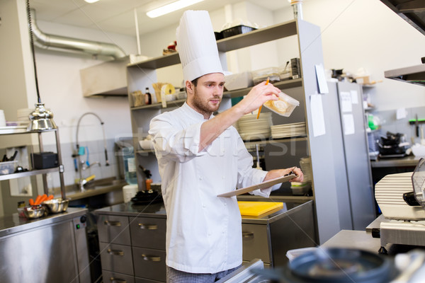 chef with clipboard doing inventory at kitchen Stock photo © dolgachov