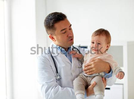 happy doctor or pediatrician with baby at clinic Stock photo © dolgachov