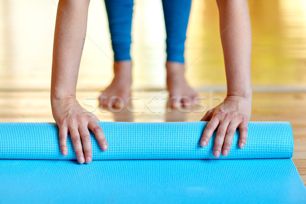 woman hands rolling yoga mat at gym or studio Stock photo © dolgachov