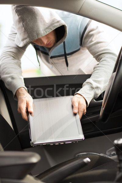 thief stealing laptop from the car Stock photo © dolgachov