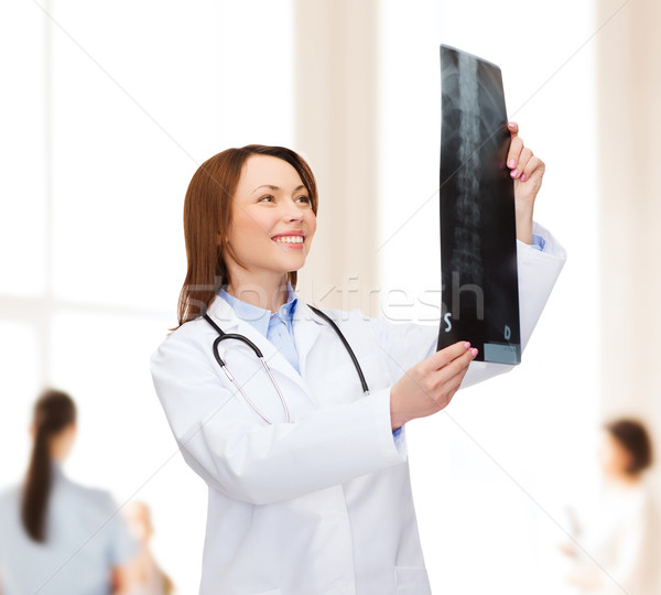 Stock photo: smiling female doctor looking at x-ray