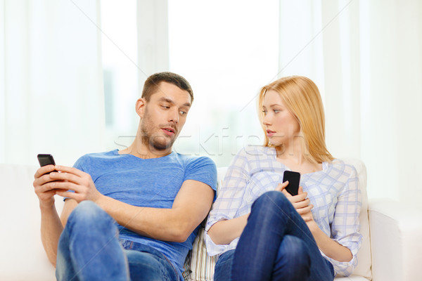 concentrated couple with smartphones at home Stock photo © dolgachov
