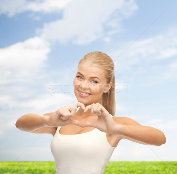 Donna sorridente a forma di cuore gesto amore donna Foto d'archivio © dolgachov