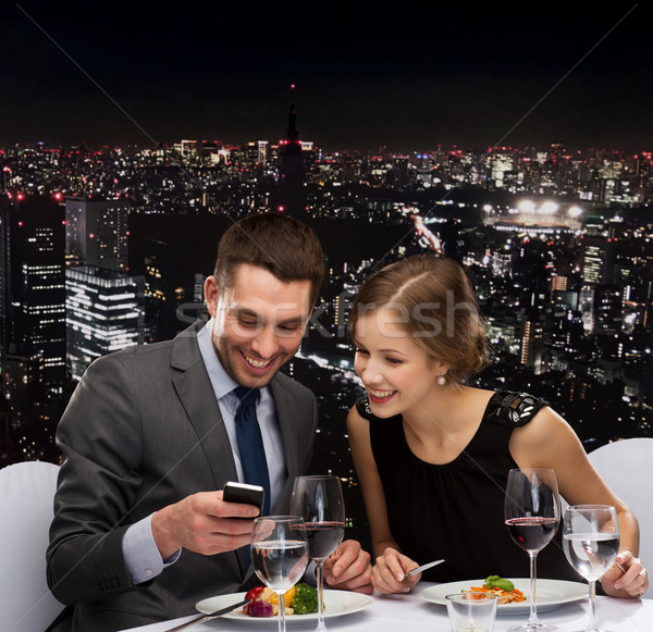 smiling couple eating main course at restaurant Stock photo © dolgachov