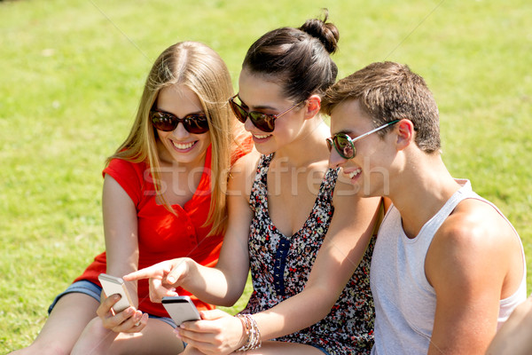 Stockfoto: Glimlachend · vrienden · smartphones · vergadering · park · vriendschap