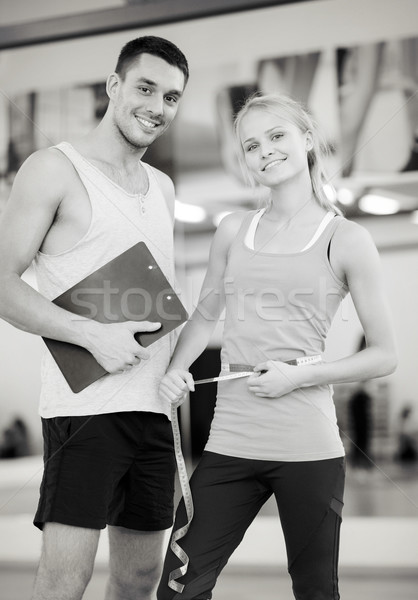 two smiling people with clipboard and measure tape Stock photo © dolgachov
