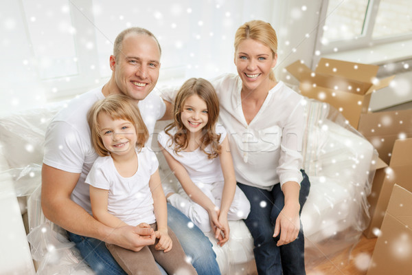 smiling parents and two little girls at new home Stock photo © dolgachov