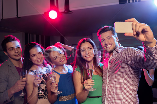 Stock photo: friends with glasses and smartphone in club