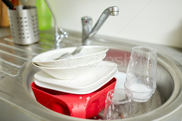 Stock photo: close up of dirty dishes washing in kitchen sink