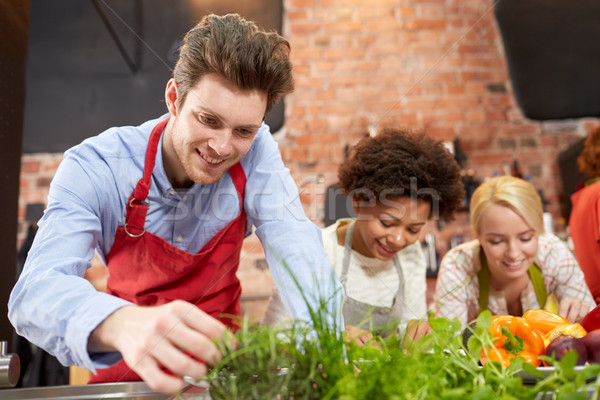 happy friends cooking and decorating dishes Stock photo © dolgachov