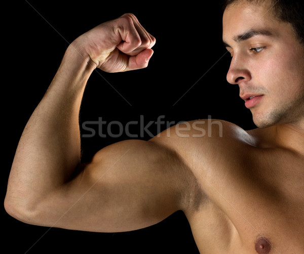 close up of young man showing biceps Stock photo © dolgachov