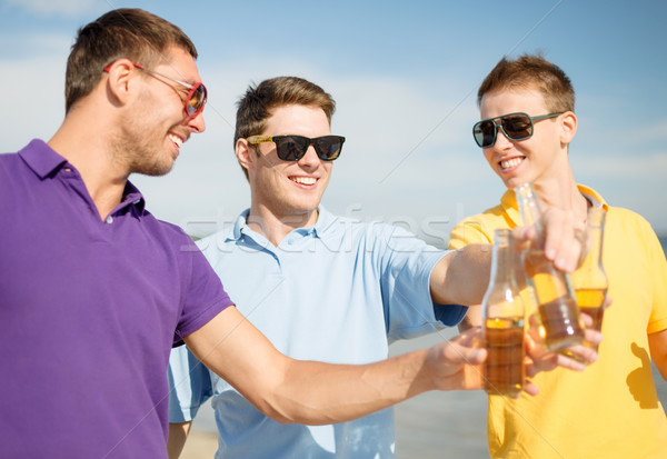 Feliz amigos cerveja garrafas praia verão Foto stock © dolgachov