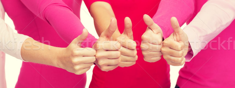 close up of women in pink shirts showing thumbs up Stock photo © dolgachov