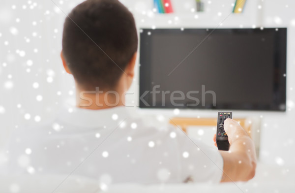 Stock photo: man watching tv and changing channels at home