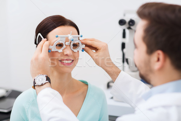 optician with trial frame and patient at clinic Stock photo © dolgachov