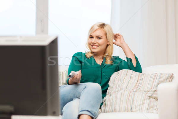 улыбающаяся женщина удаленных смотрят телевизор домой телевидение Сток-фото © dolgachov