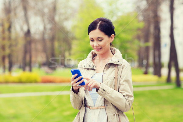 Mosolygó nő hív okostelefon park italok szabadidő Stock fotó © dolgachov