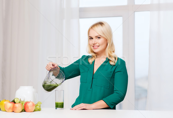 happy woman with blender jug pouring juice at home Stock photo © dolgachov