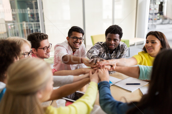 group of international students with hands on top Stock photo © dolgachov