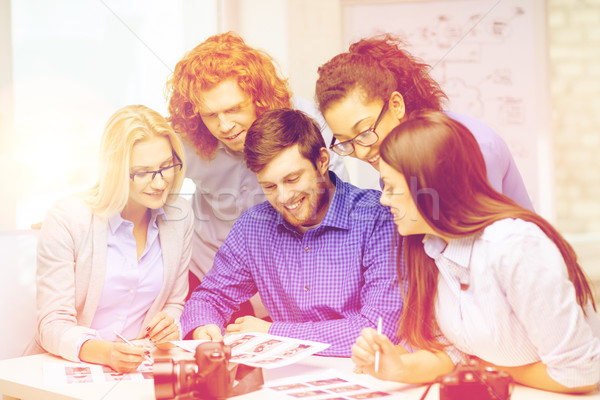 smiling team with photocamera and images in office Stock photo © dolgachov