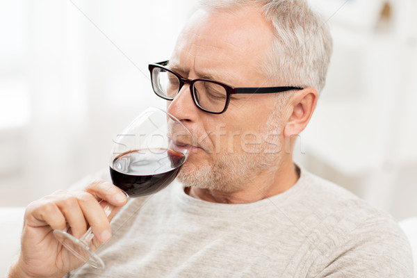 senior man drinking red wine from glass at home Stock photo © dolgachov