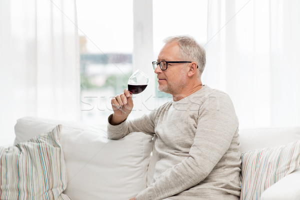 senior man drinking red wine from glass at home Stock photo © dolgachov