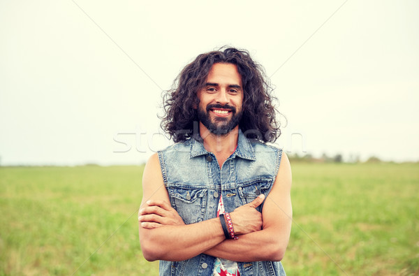 smiling young hippie man on green field Stock photo © dolgachov