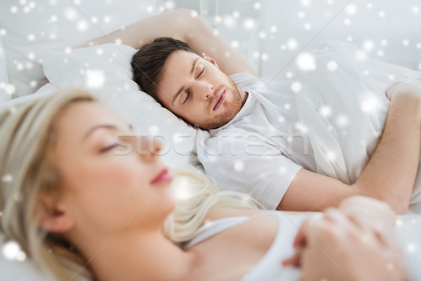 happy couple sleeping in bed at home Stock photo © dolgachov