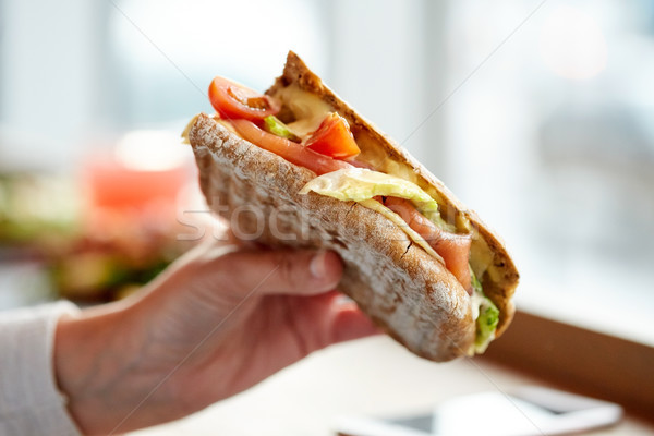 Kéz lazac panini szendvics éttermi étel vacsora Stock fotó © dolgachov
