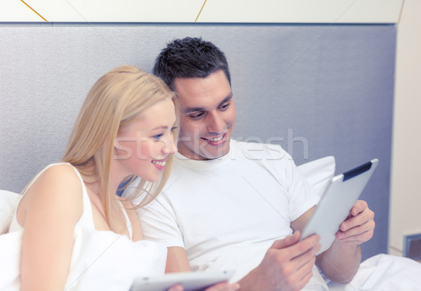 smiling couple in bed with tablet pc computers Stock photo © dolgachov