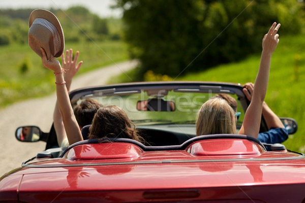happy friends driving in cabriolet car at country Stock photo © dolgachov