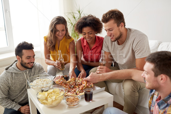 Feliz amigos bebidas alimentação pizza casa Foto stock © dolgachov