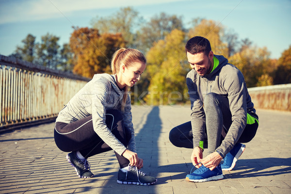 Glimlachend paar schoenveters buitenshuis fitness sport Stockfoto © dolgachov